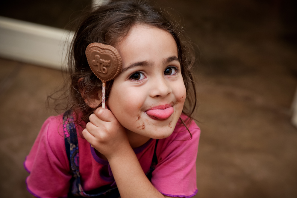 ילדה מחייכת עם מקל של שוקולד