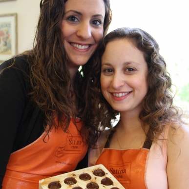 שתי נשים בסדנת שוקולד, מחזיקות תבנית פרלינים