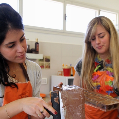 שתי נשים מכינות פרלינים בסדנת שוקולד