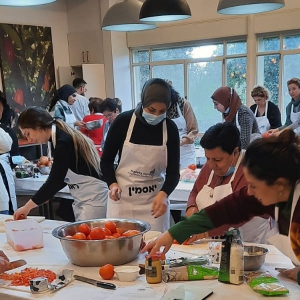 סדנת בישול - מלא אנשים בחלל עובדים ביחד לבשל ארוחה